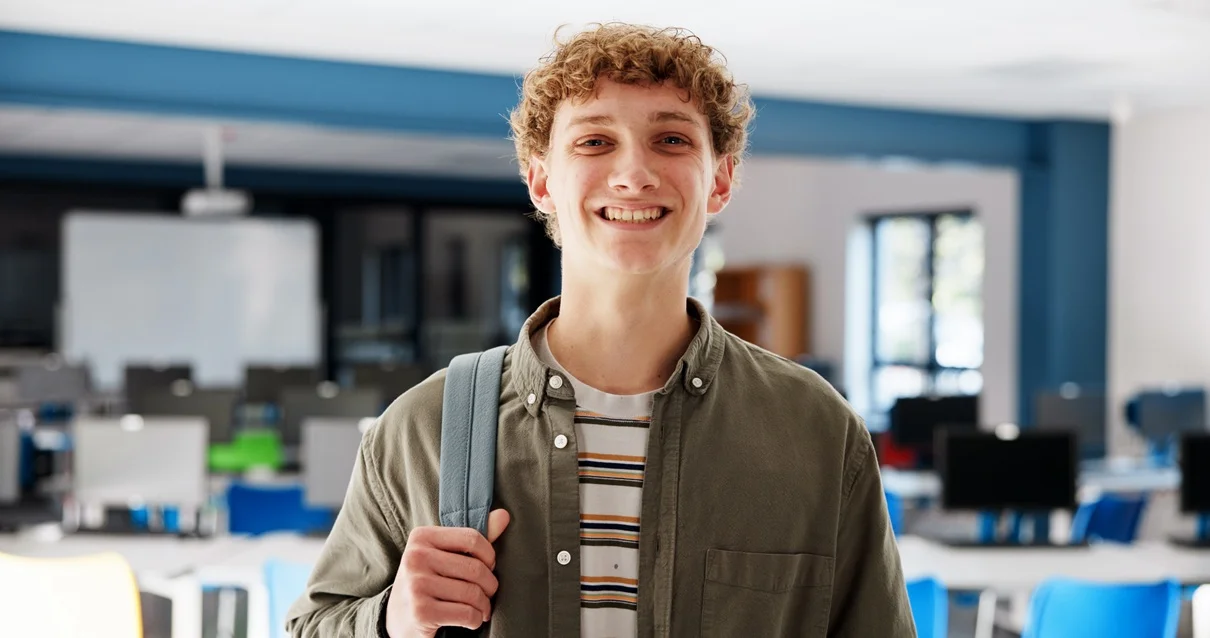 Auf einem Schreibtisch steht ein Laptop neben diversen Arbeitsutensilien wie Stiften, Block, einer Kamera