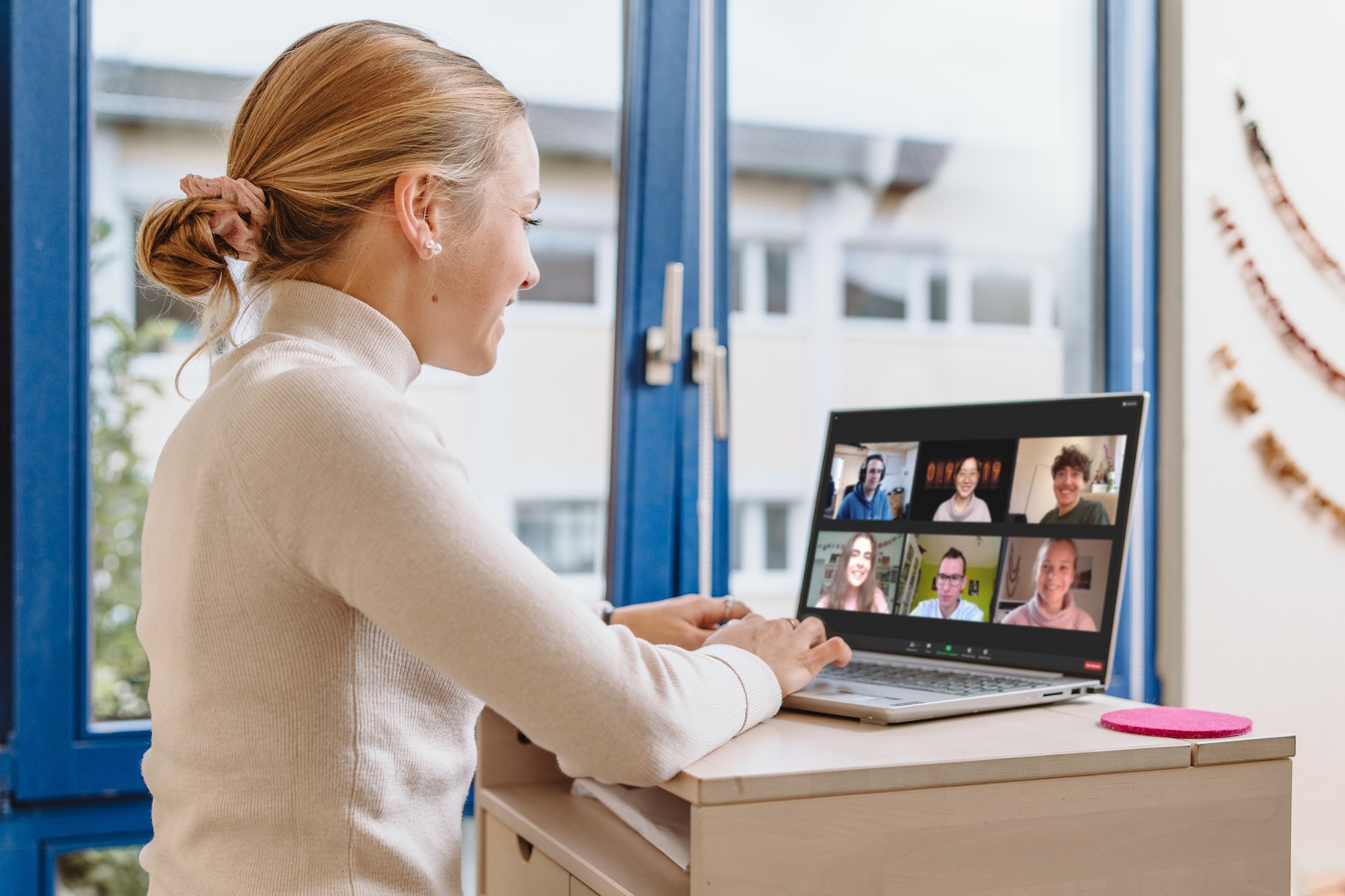 Eine Frau sitzt vor einem Laptop und nimmt an einer Videokonferenz teil